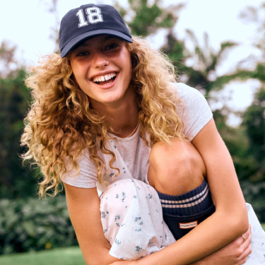 Woman wearing baseball cap and long socks from Cotton On