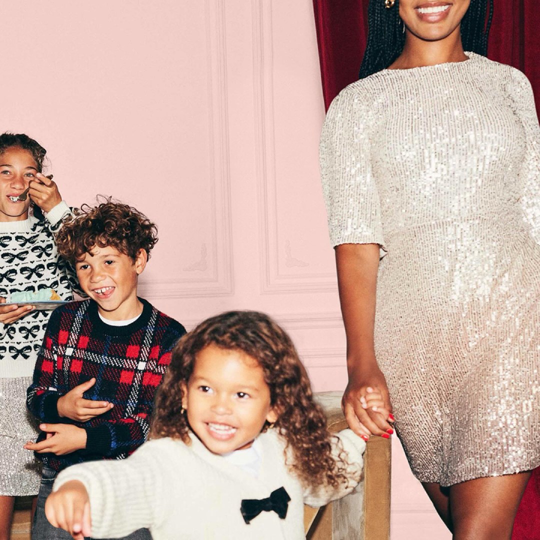 Smiling children and a woman dressed for the holidays.