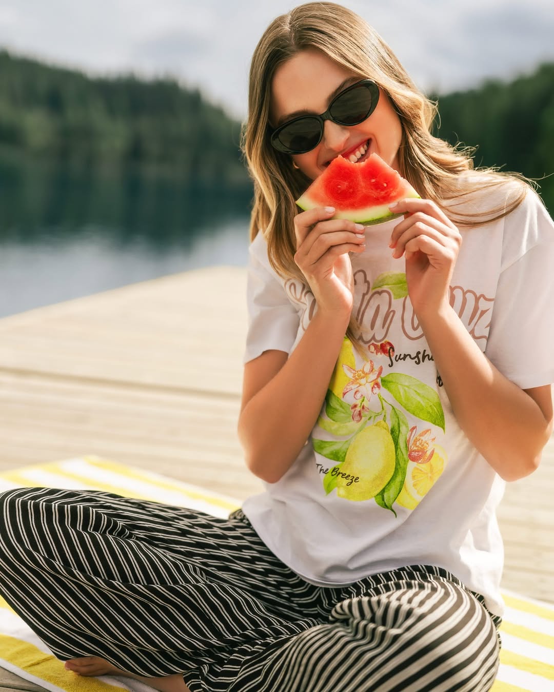 EO CHARLOTTE RUSSE a woman enjoying a slice of watermelon while wearing a relaxed outfit from Charlotte Russe